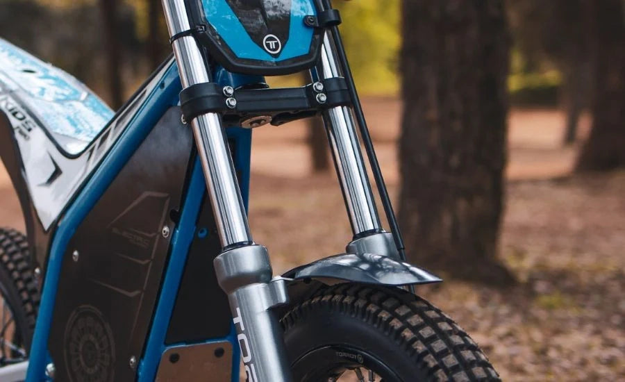 Close-up of a blue and black electric bike with a blurred natural background