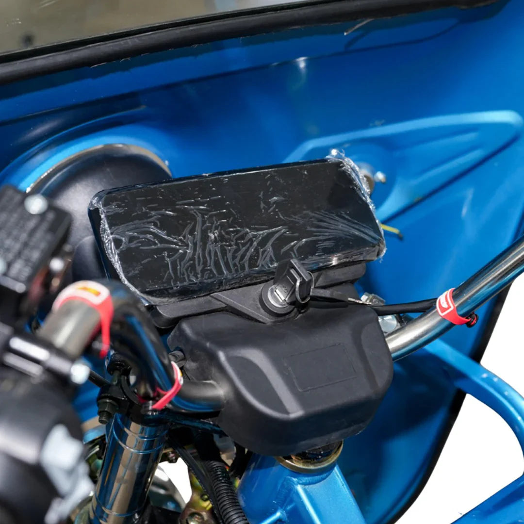 Close-up of a motorcycle's handlebar with a black control panel and blue background