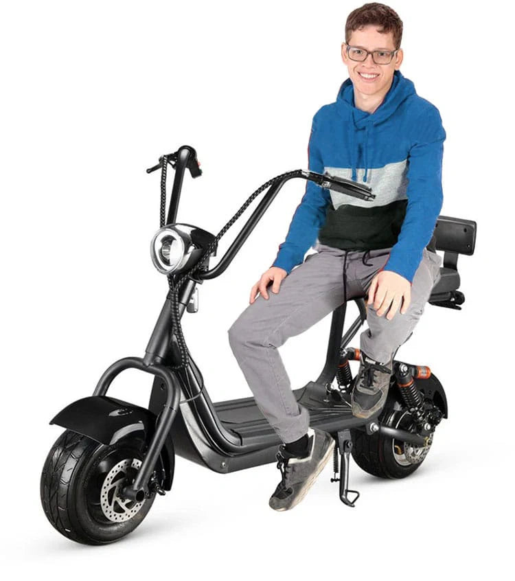 Person sitting on a black electric scooter against a white background