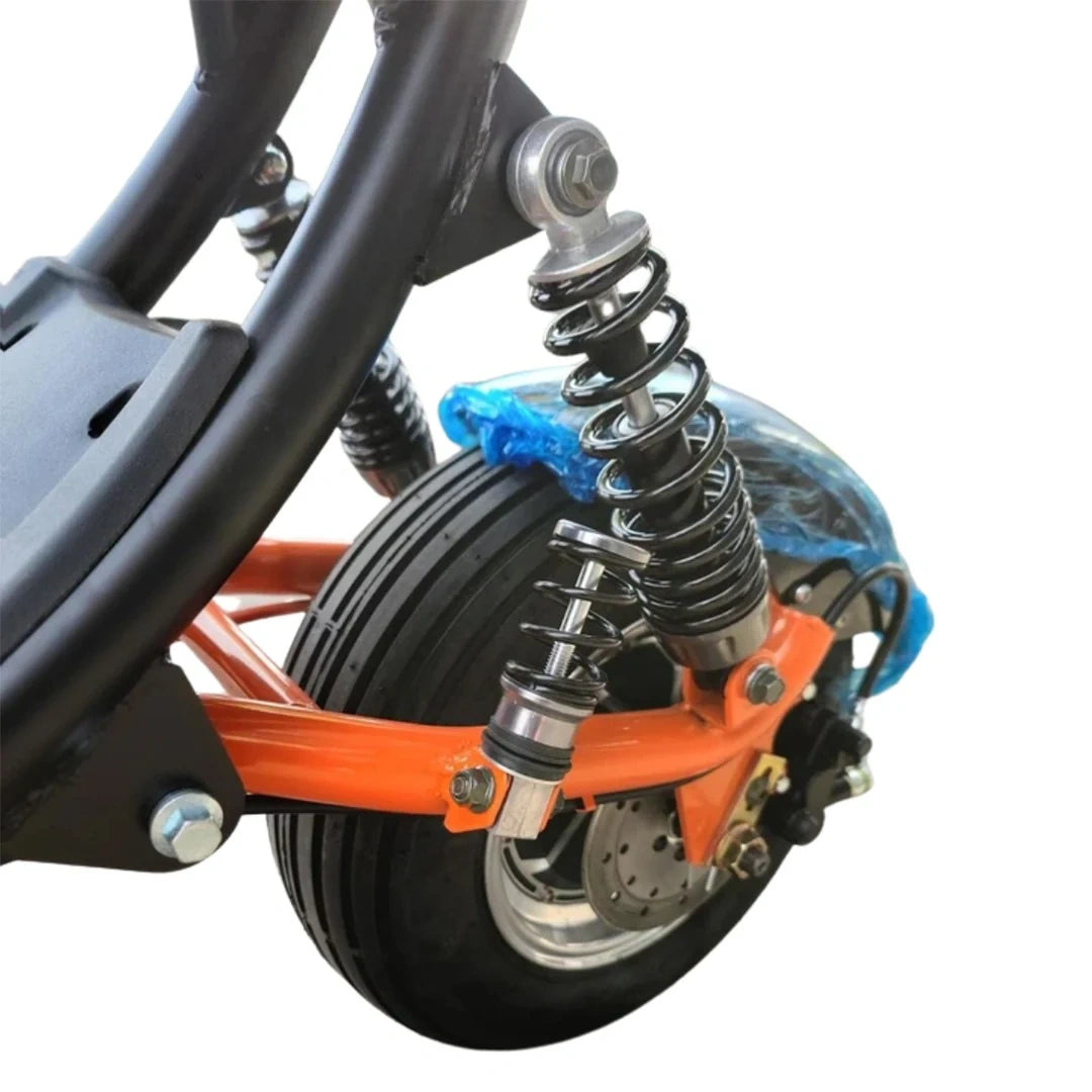 Close-up of a scooter's suspension system with an orange suspension fork and black wheel.
