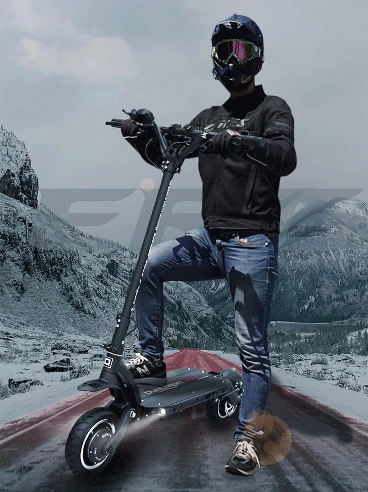 Person riding an electric scooter on a snowy mountain road
