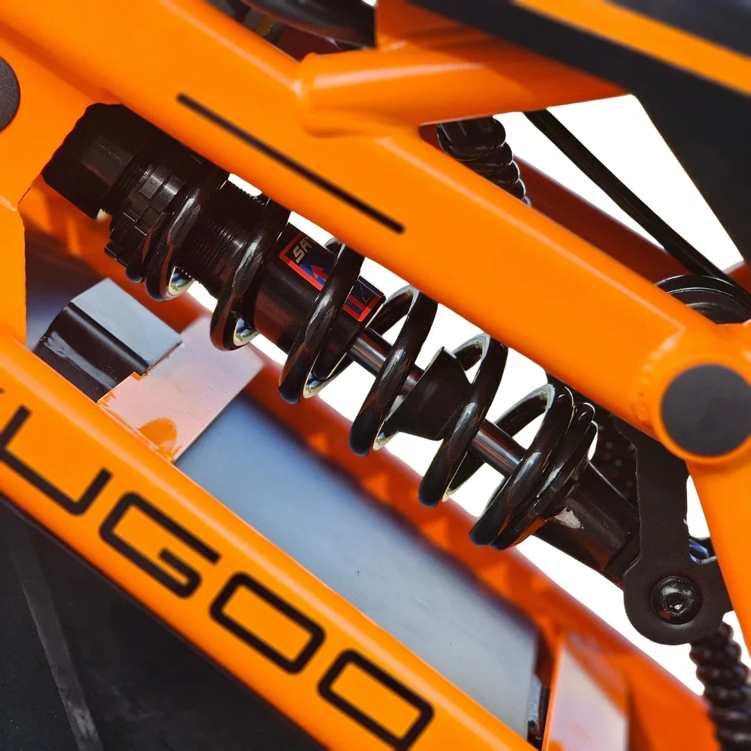 Close-up of an orange off-road vehicle suspension system with 'UGOO' branding.