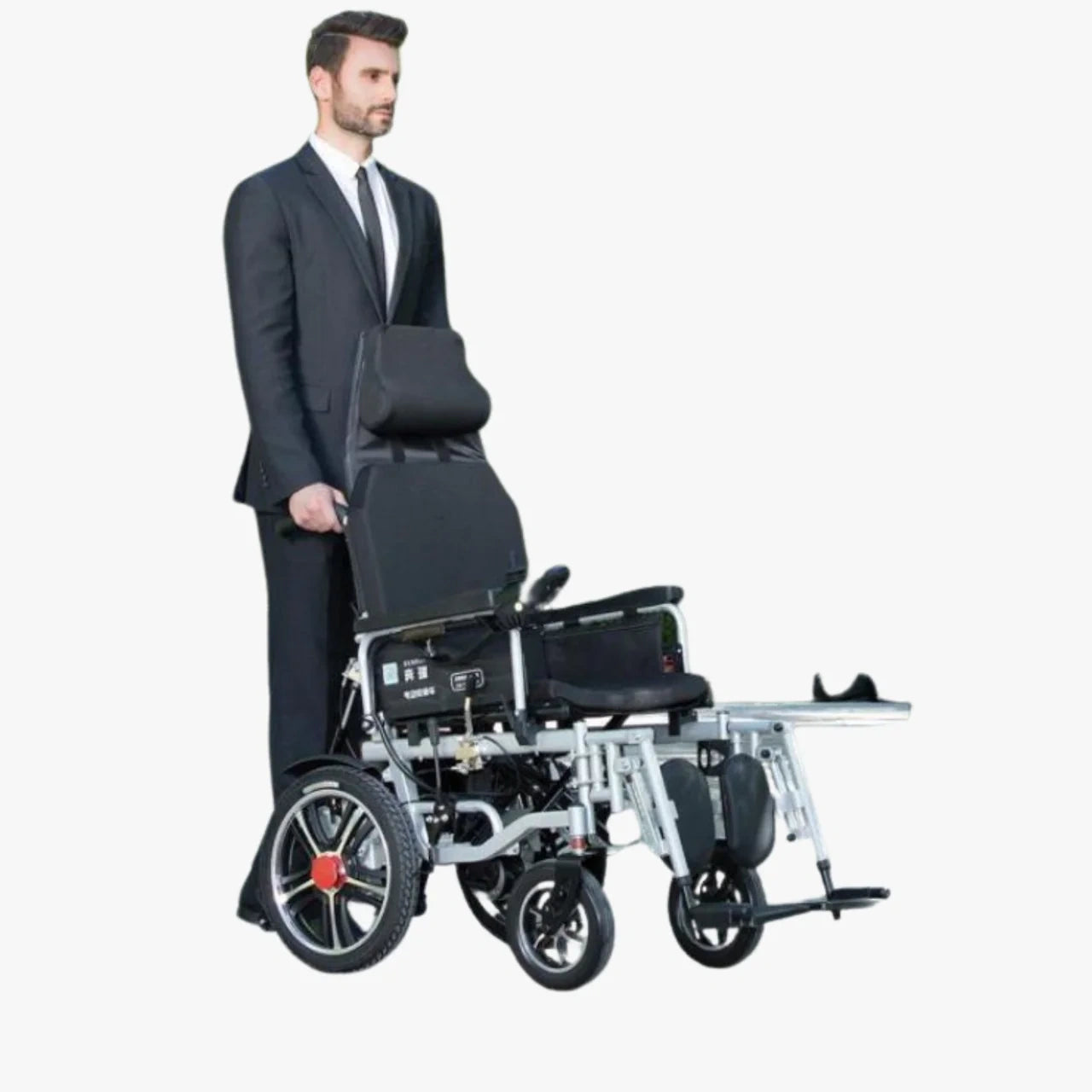 Man in a suit pushing a black electric wheelchair on a white background