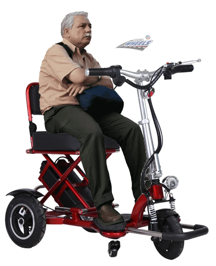 Man sitting on a red and black mobility scooter with a white background