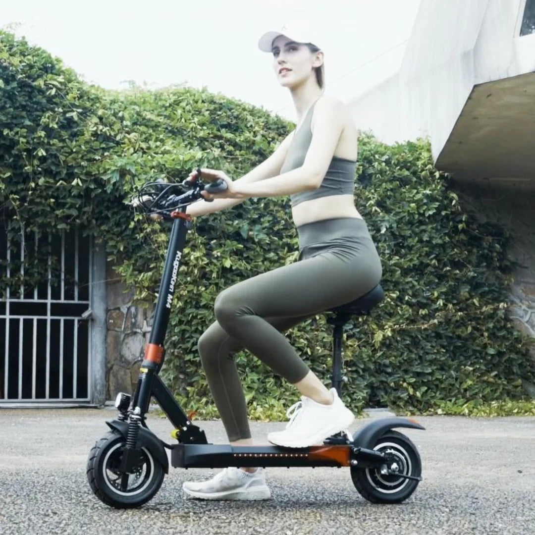 Woman riding an electric scooter outdoors with greenery in the background