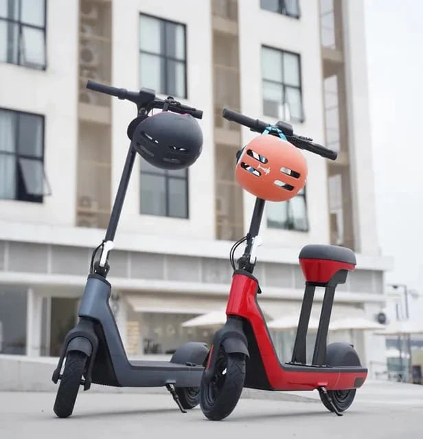 Two electric scooters with helmets on a city street.
