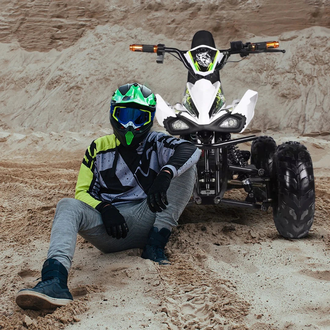 Person in protective gear sitting next to an ATV in a desert setting