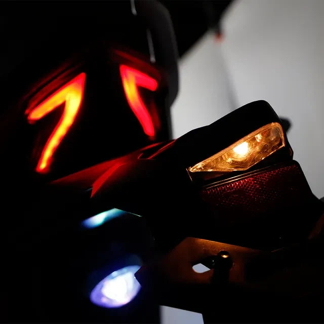 Close-up of a motorcycle's turn signal and taillight with a blurred background
