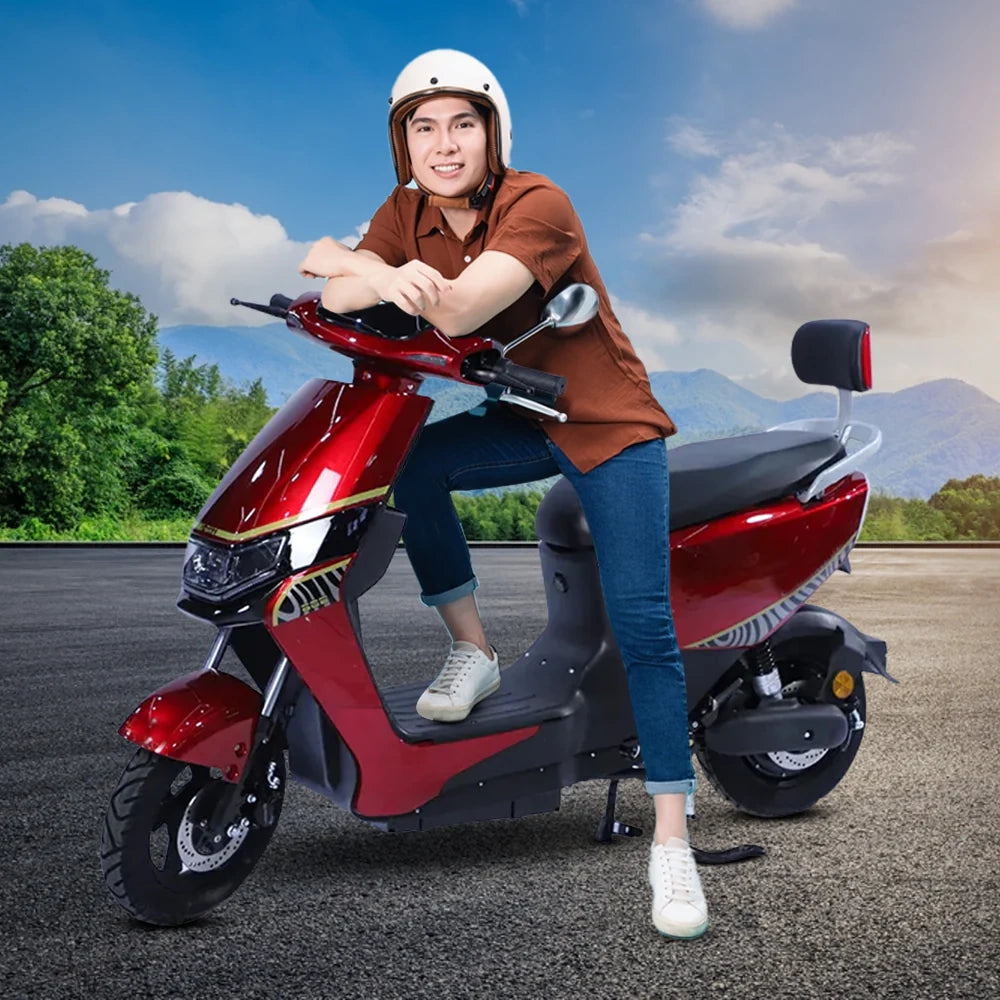 Person sitting on a red scooter with a scenic background