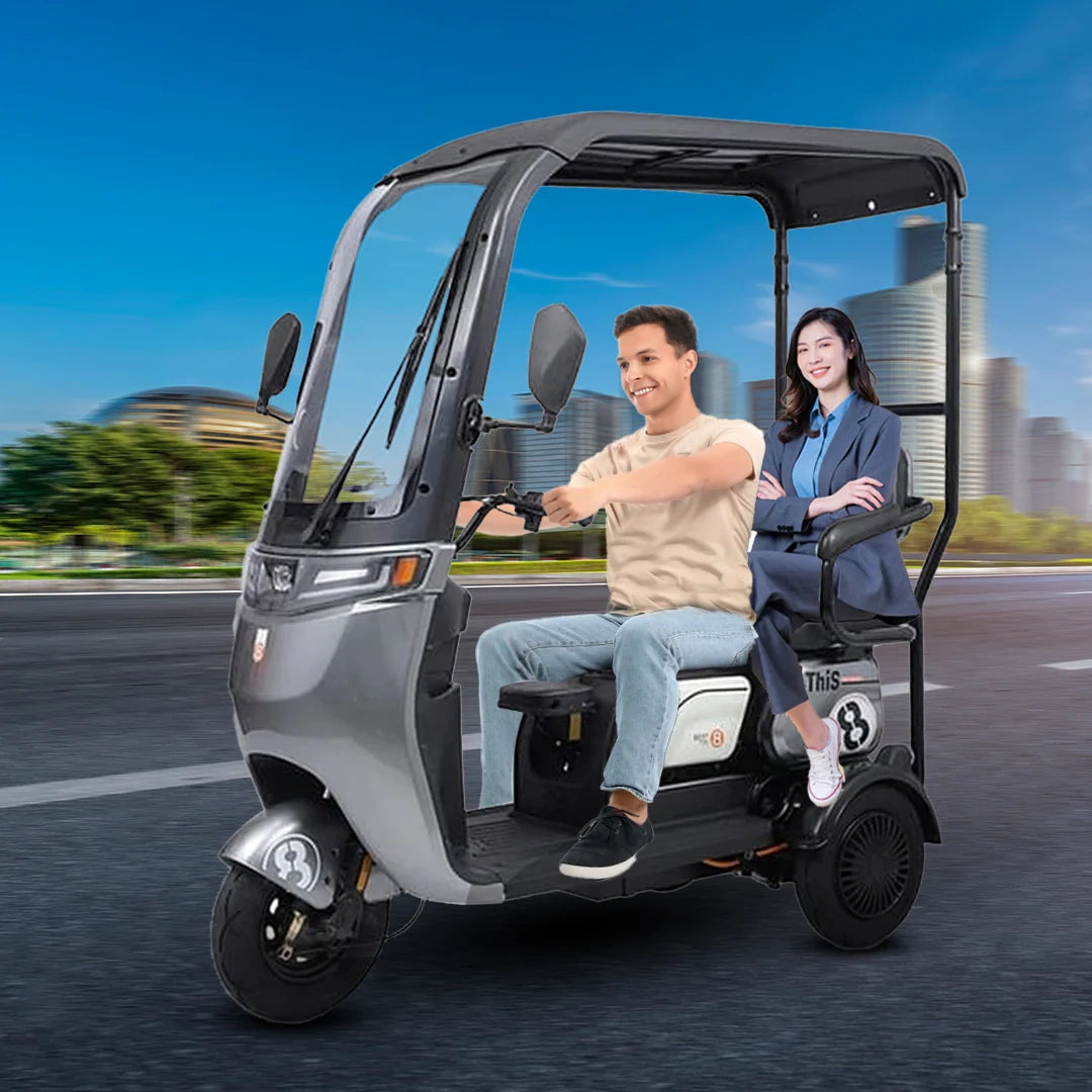 Two people riding in a three-wheeled electric vehicle with a cityscape in the background