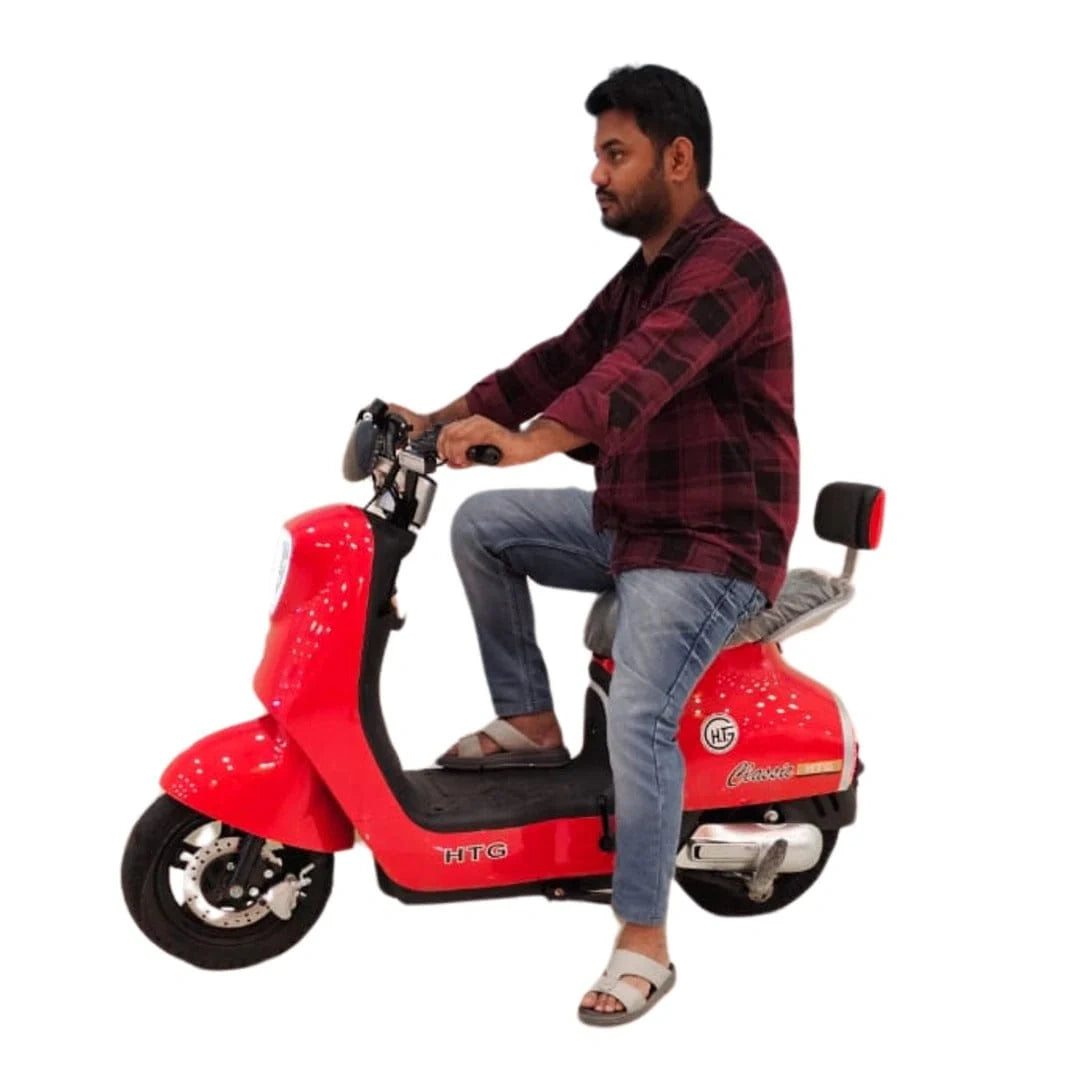 Person sitting on a red electric scooter with a white background