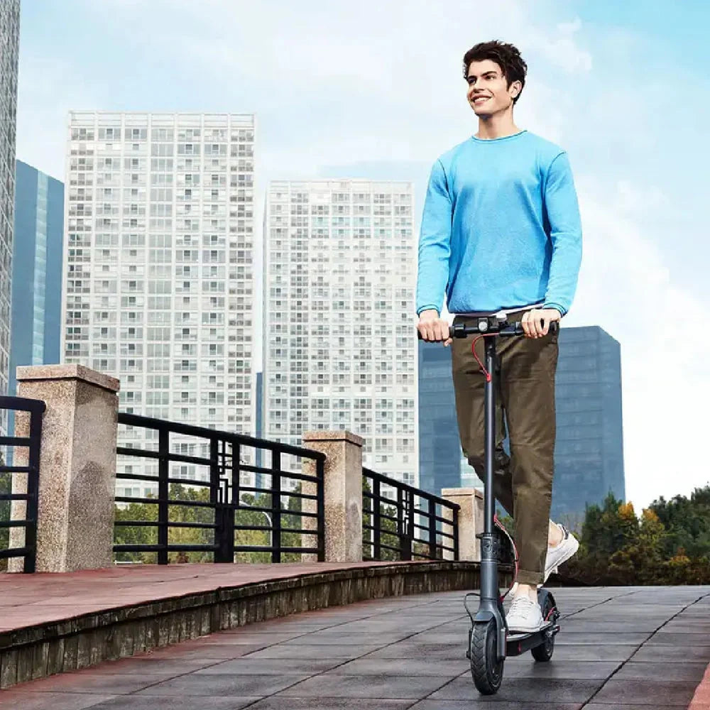 Man riding an electric scooter with city skyline in the background