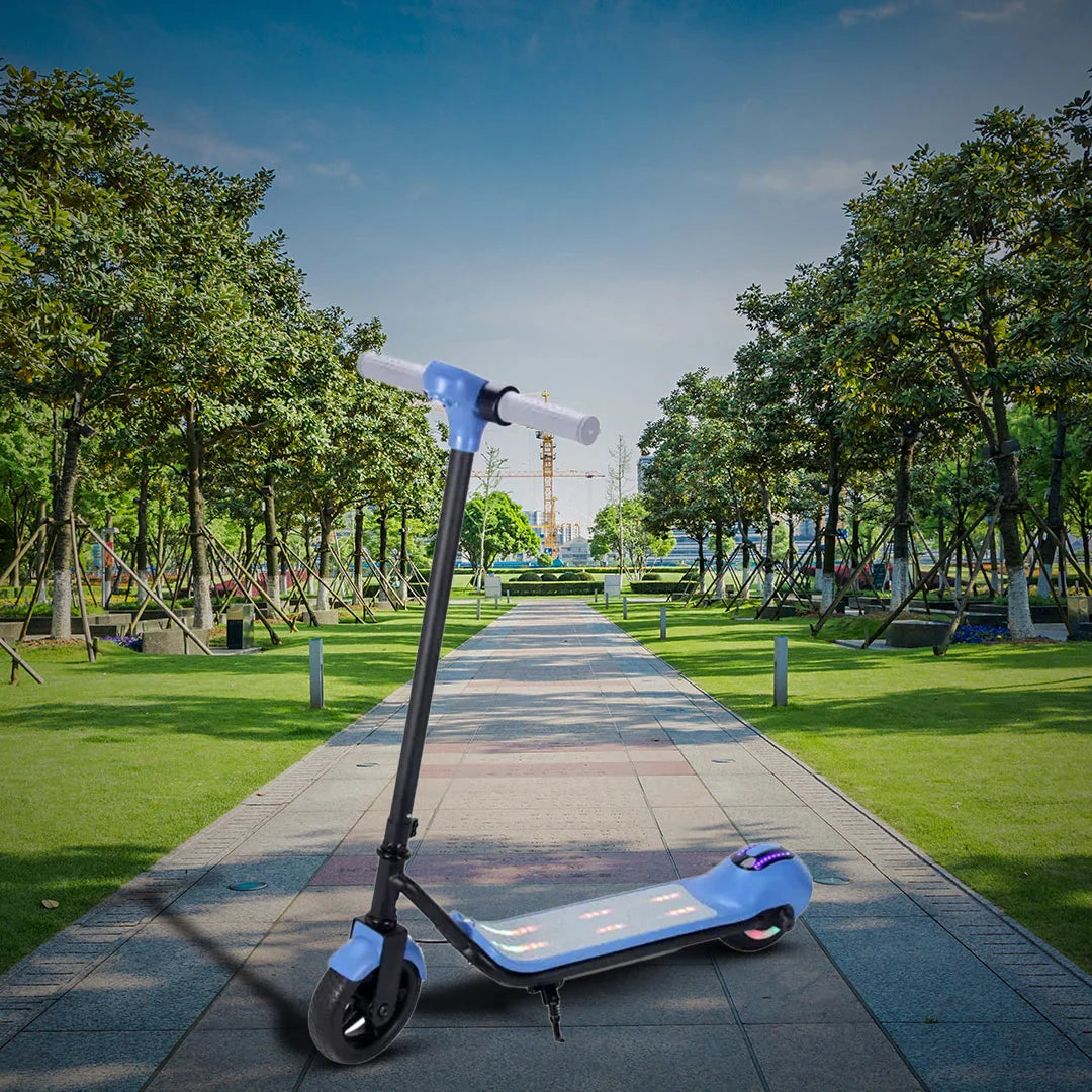 Electric scooter on a pathway in a park with trees and playground equipment.