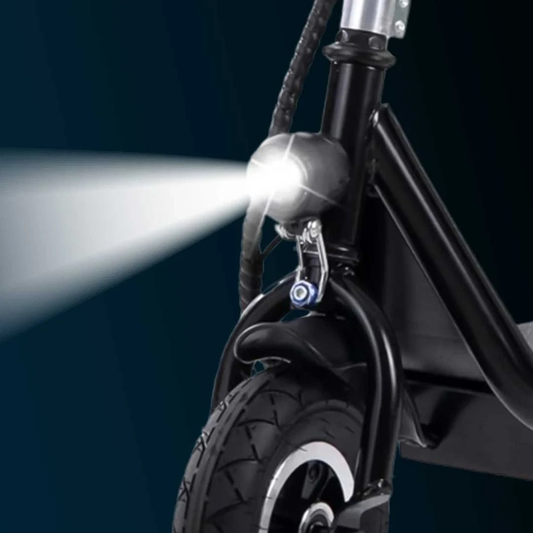 Close-up of a scooter's headlight shining on a dark background