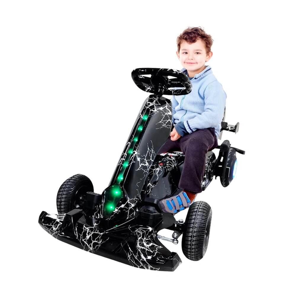 Child sitting on a black toy go-kart with green lights on a white background