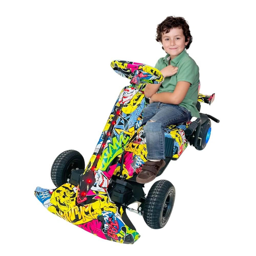 Child sitting on a colorful toy motorcycle with graffiti design on a white background