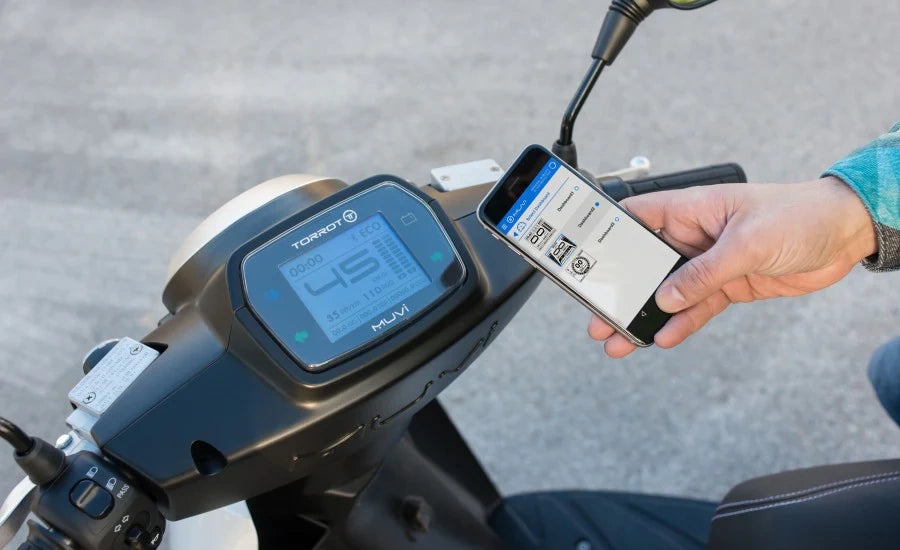 Person using a smartphone app on a motorcycle with a digital display.