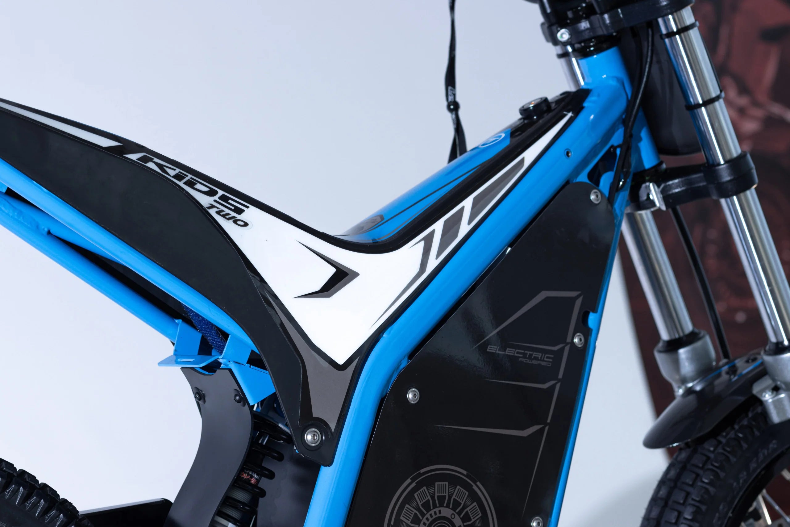 Close-up of a blue and black electric bike with visible branding on a white background