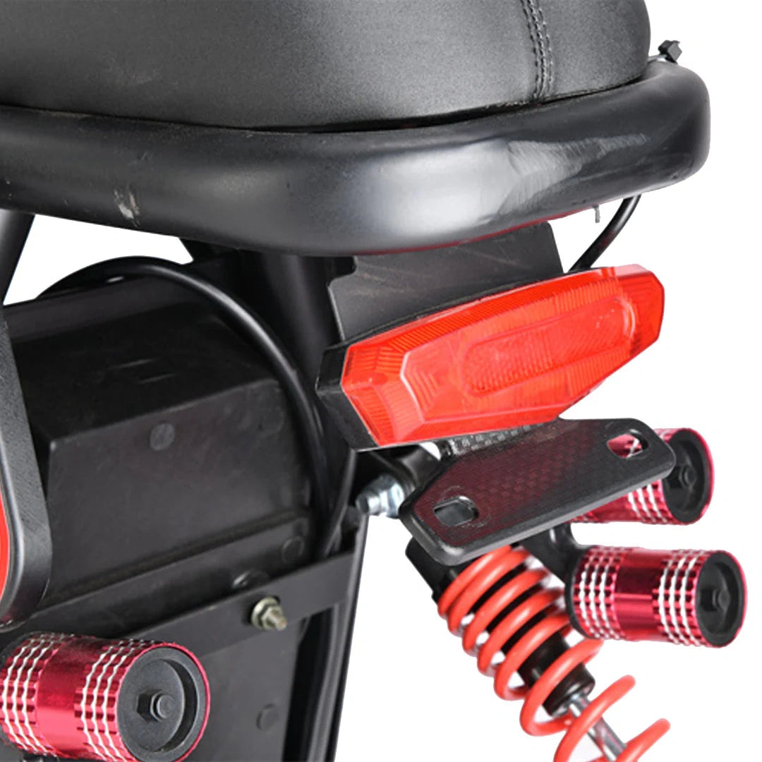 Close-up of a motorcycle's rear section with red reflectors and suspension components.