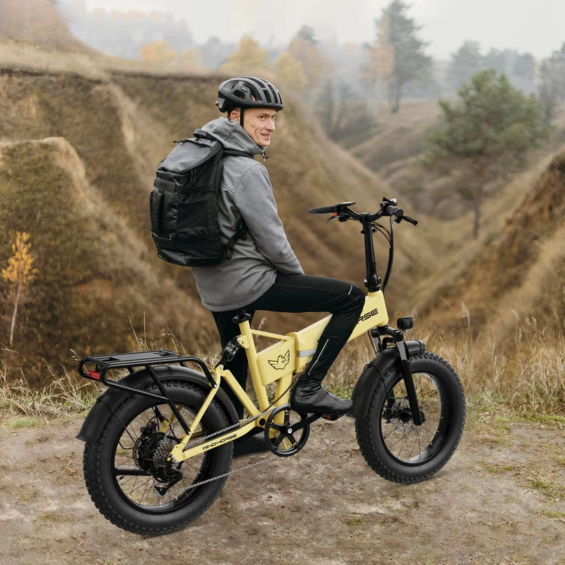 Person riding a yellow electric bike in a natural landscape