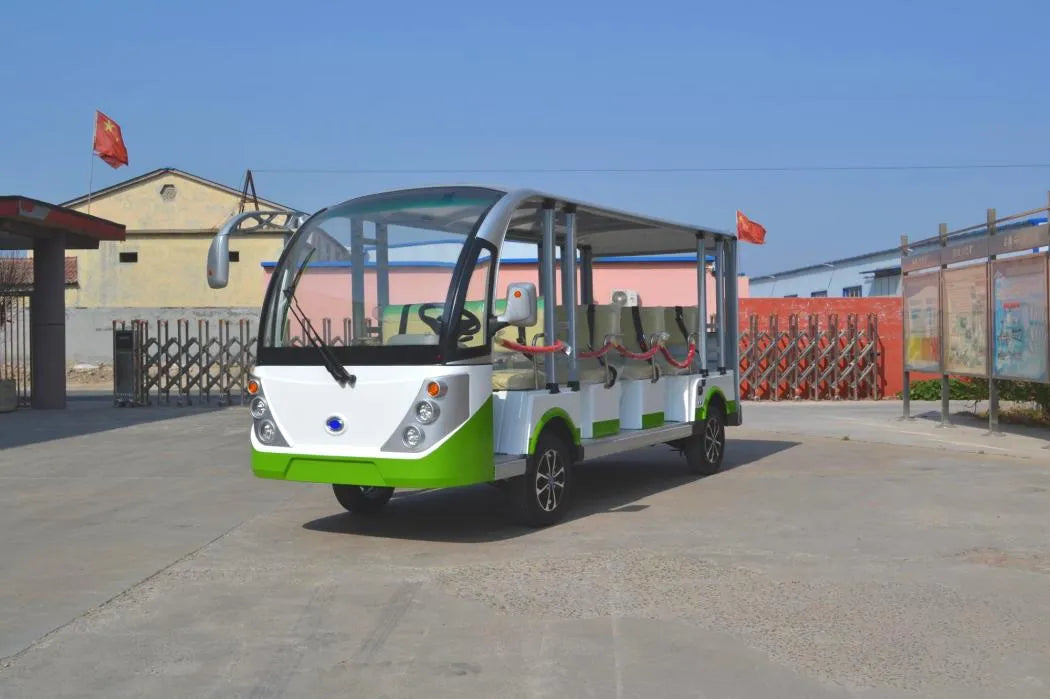 Small electric bus on a concrete surface with buildings and flags in the background