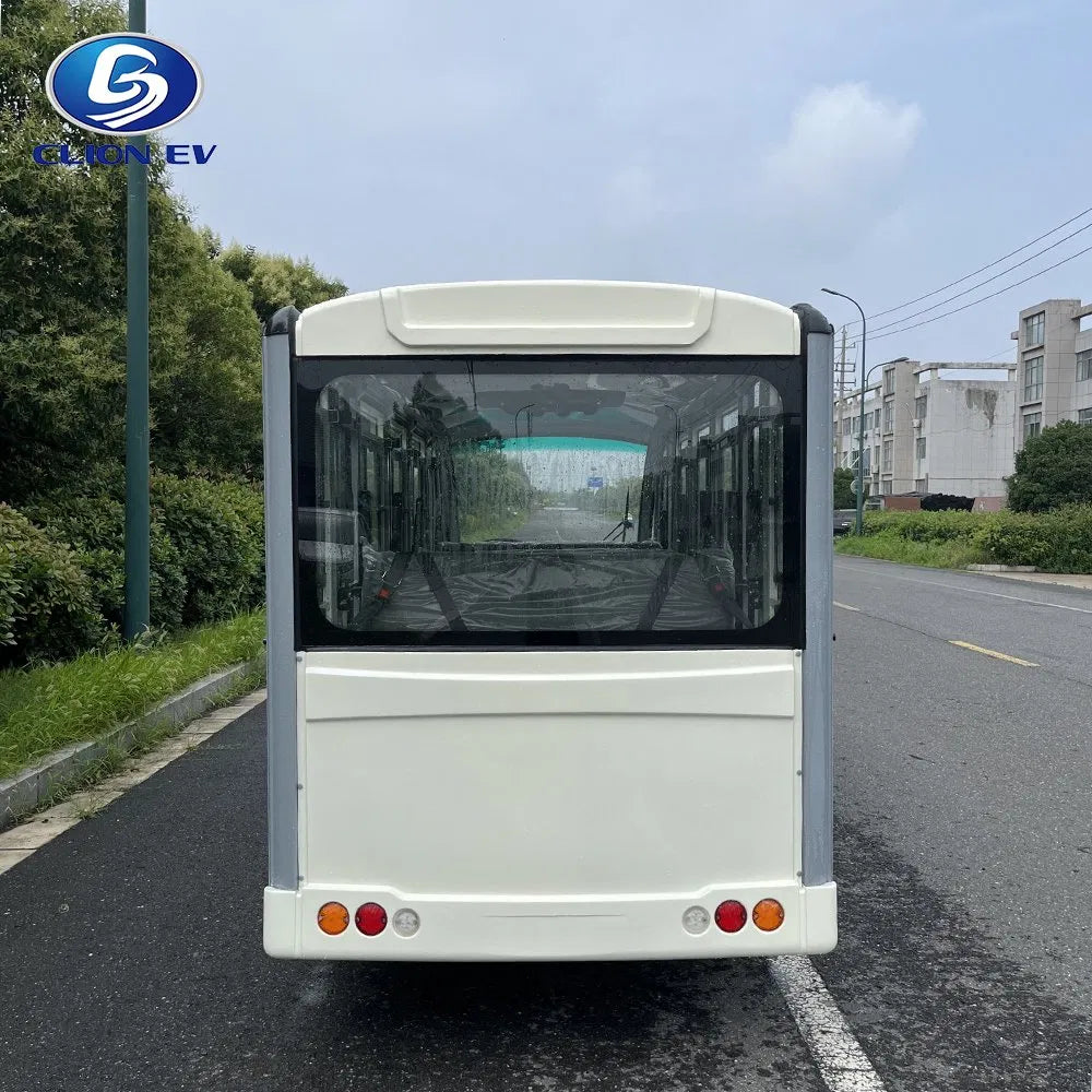 Small electric vehicle on a road with trees and buildings in the background