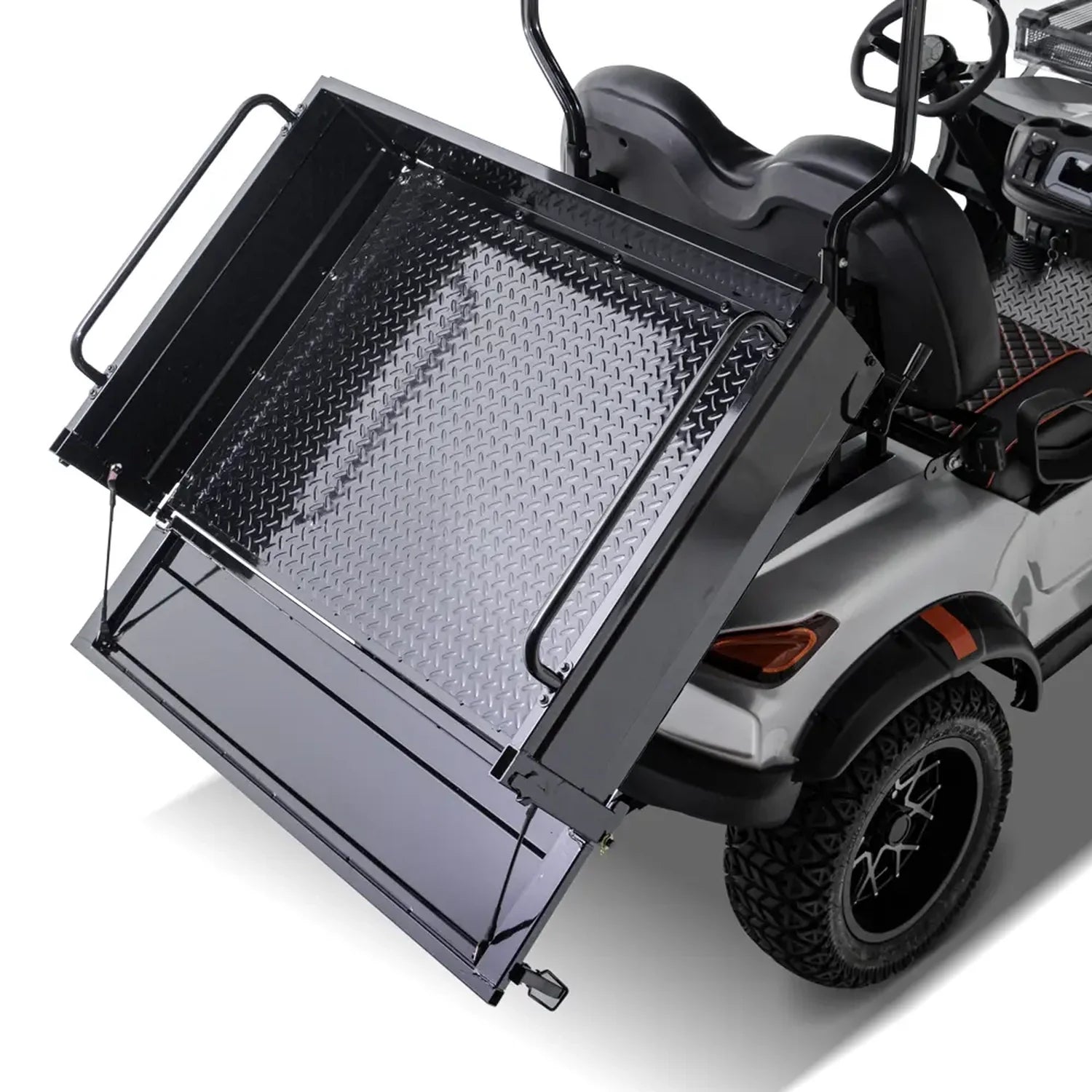 ocean cartz close-up rear view of a silver utility golf cart demonstrating its rear dump bed or tilting mechanism. The black metal cargo box, which features a diamond-plate floor, is partially raised. The image highlights the heavy-duty function of the electric work cart, including the black fender flare, all-terrain tire, and custom wheel, set against a white background.