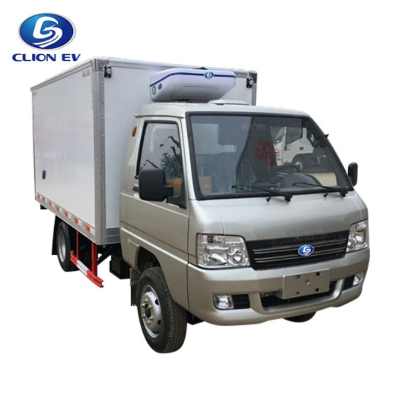 ocean cartz three-quarter front studio shot of a silver electric refrigerated truck with a large, white insulated cargo box, set against a white background. This specialized electric commercial vehicle is a heavy-duty refrigerator delivery van for cold chain logistics, featuring a cab-over-engine design and a white and blue refrigeration unit mounted on the box roof.