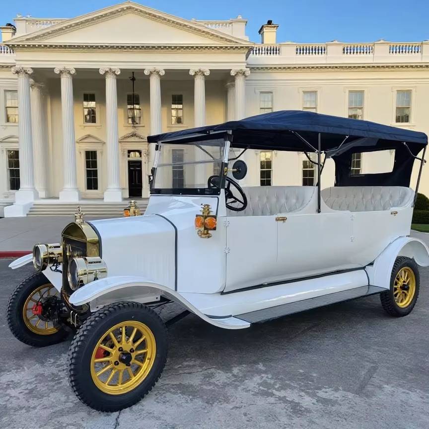 Vintage white car with yellow wheels in front of a classical building