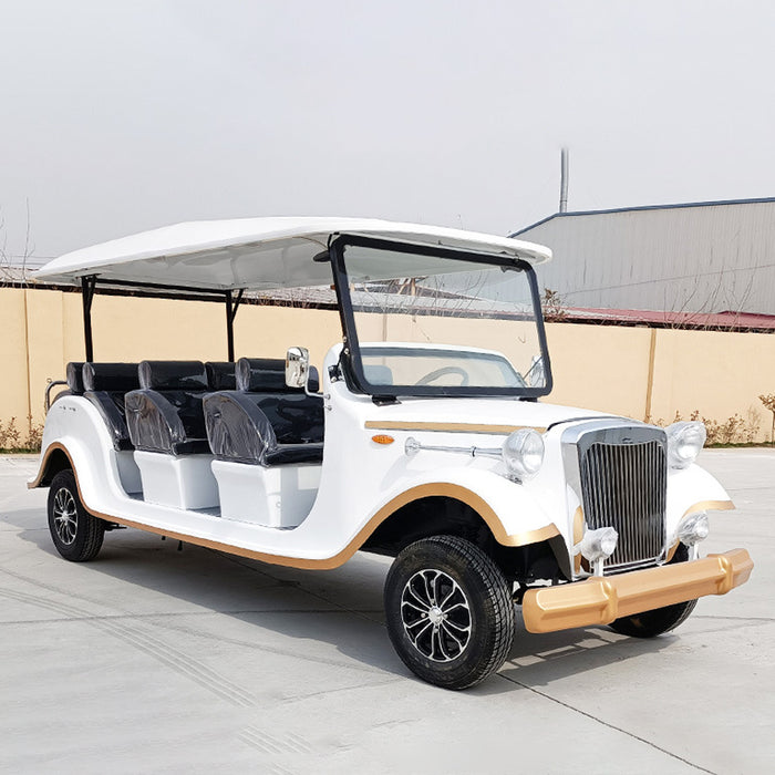White vintage-style electric car with black seats on a concrete surface.