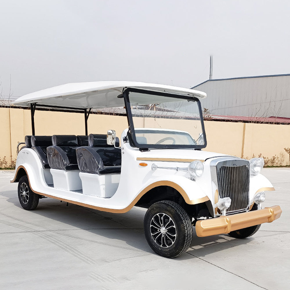 White vintage-style electric car with black seats on a concrete surface.