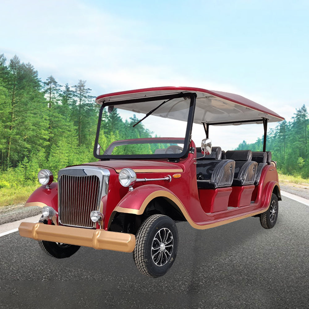 Red electric vehicle on a road with trees in the background