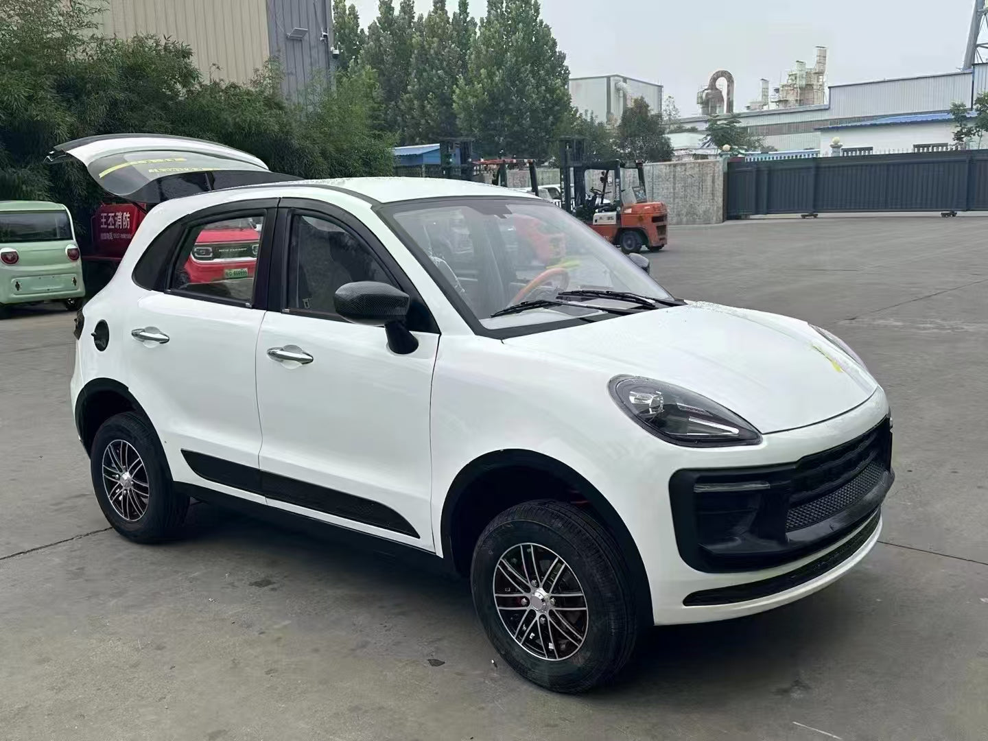 White SUV parked on a concrete surface with industrial buildings in the background