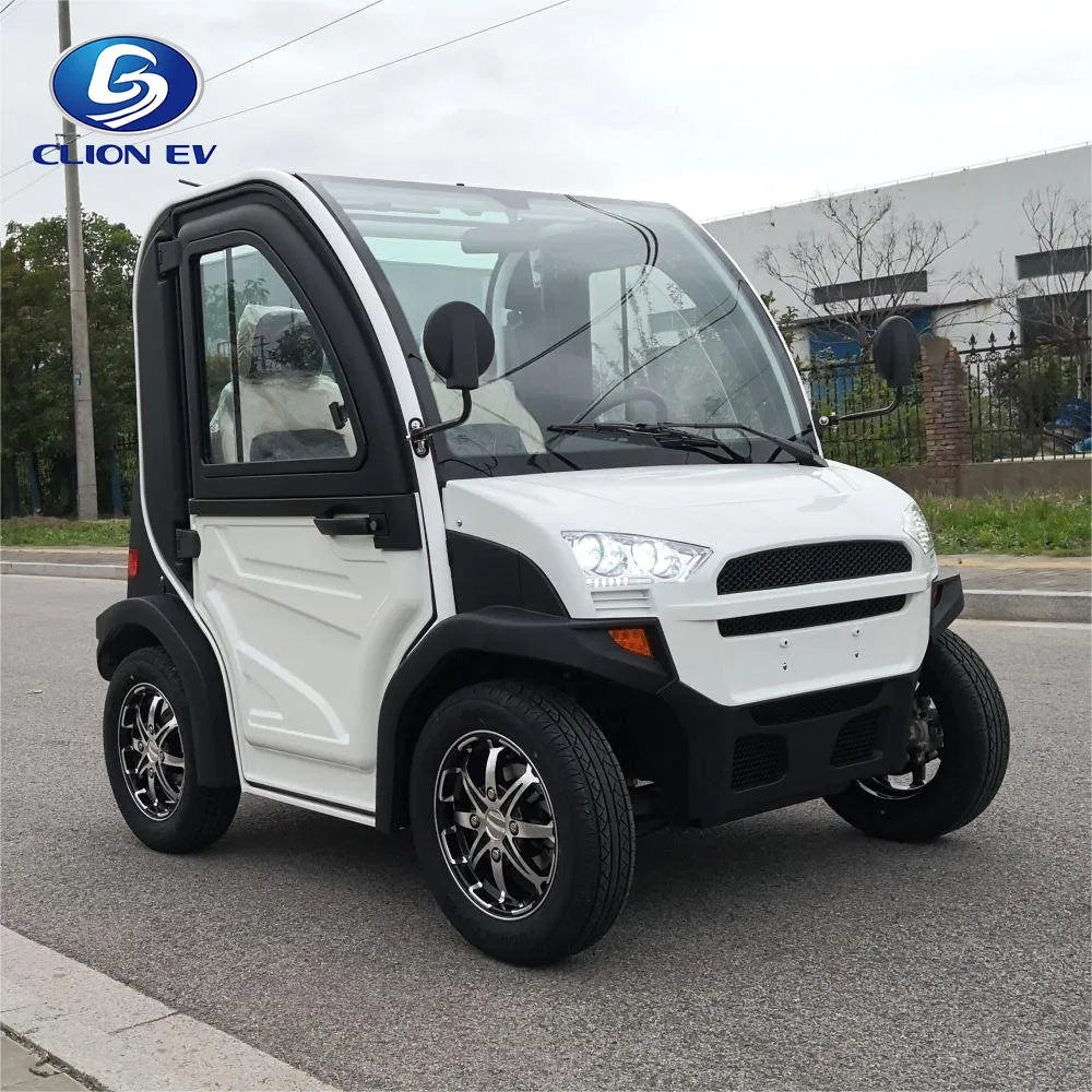 ocean cartz three-quarter front view of a white and black two-seater electric vehicle with a fully enclosed cab and a curved glass roof. This modern compact NEV or low-speed electric car is parked on an asphalt street, featuring black trim, a large windshield, and a small front grille. It is equipped with custom black and chrome alloy wheels, highlighting its use as an all-weather neighborhood electric car.