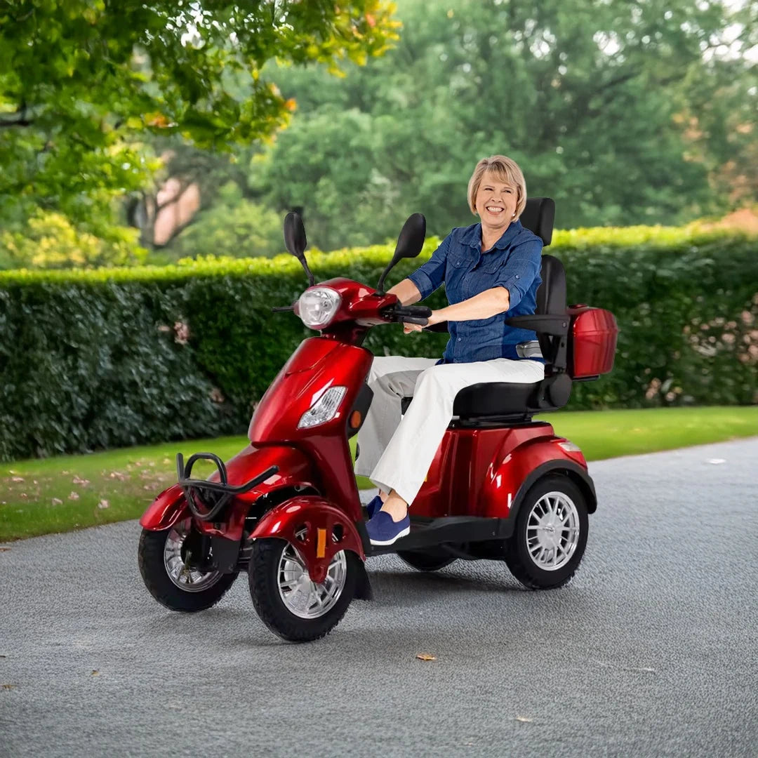 ocean cartz smiling woman riding a red heavy duty outdoor mobility scooter down a paved path in a park or suburban neighborhood. This long range electric scooter for seniors provides independent and comfortable transport, highlighting the all terrain capability and reliability of the four wheel mobility vehicle.