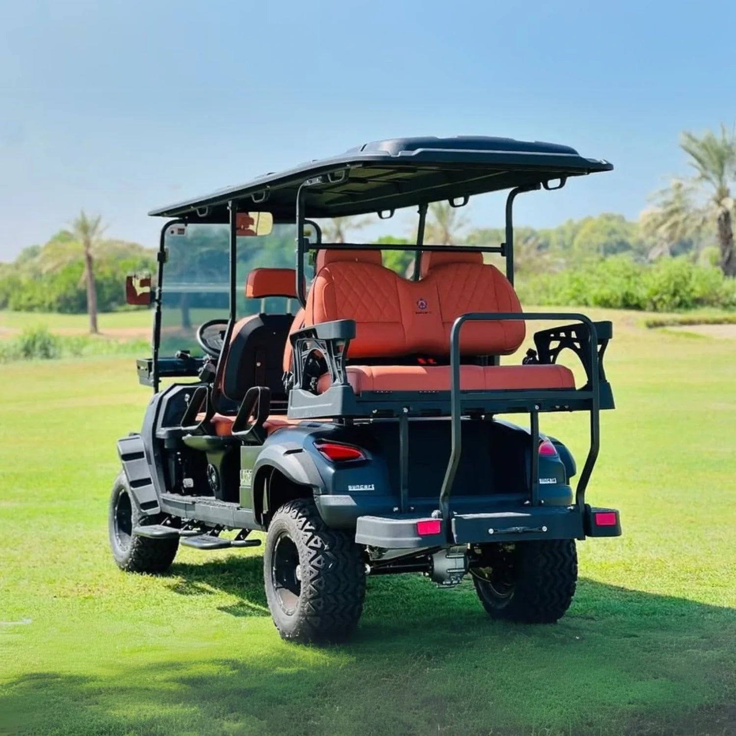 Golf cart with red seats on a grassy field