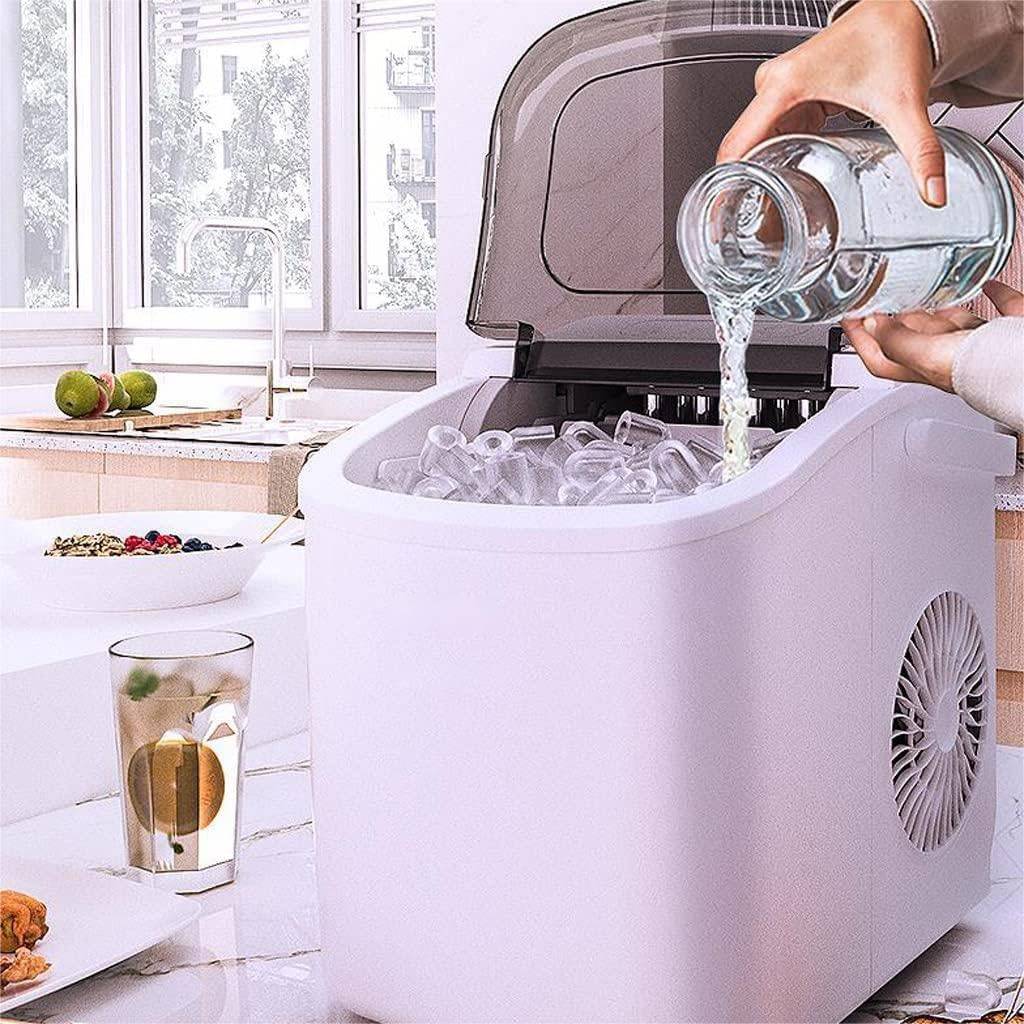 Person pouring water into a portable ice maker in a kitchen setting.