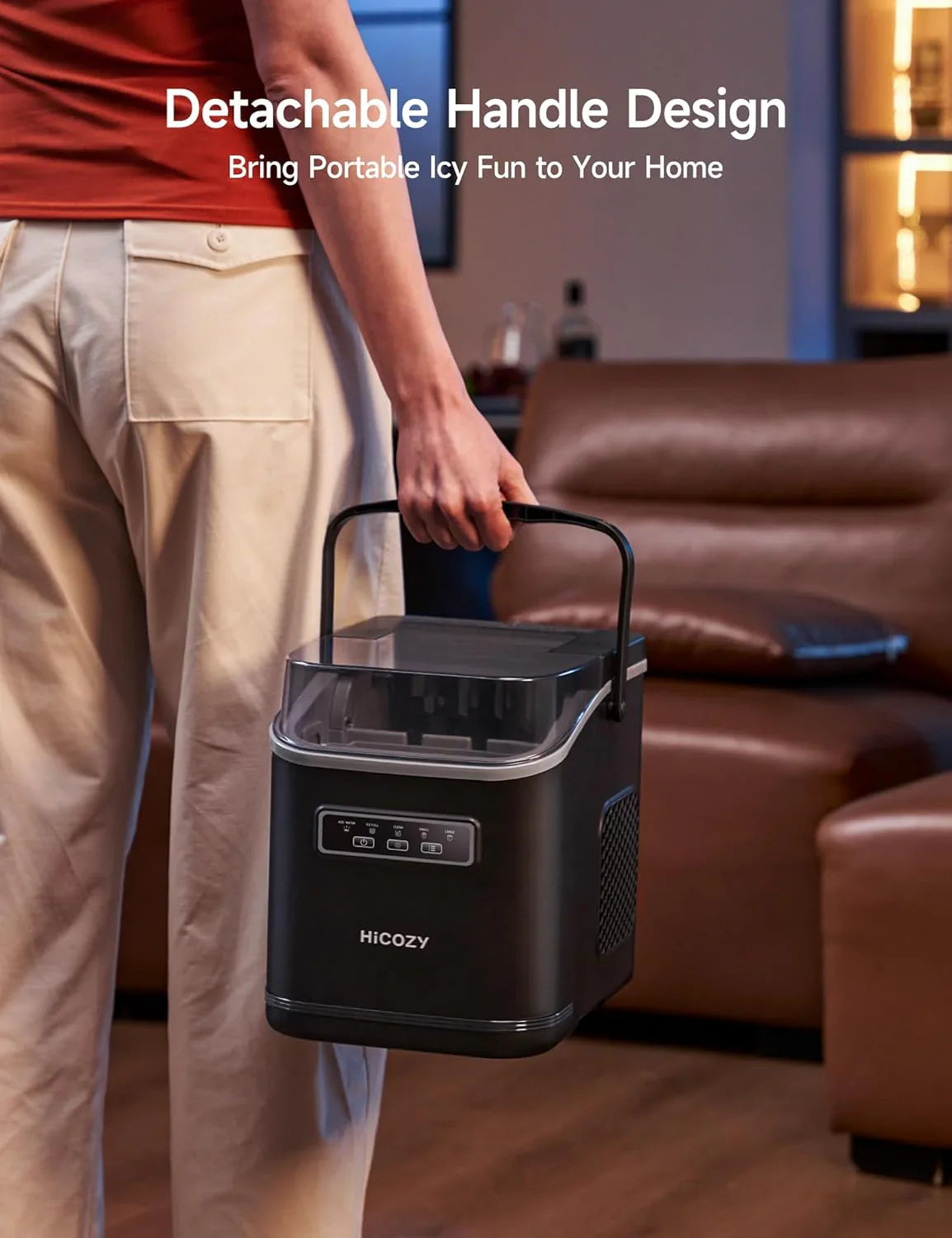 Person holding a portable ice maker with detachable handle design in a living room.