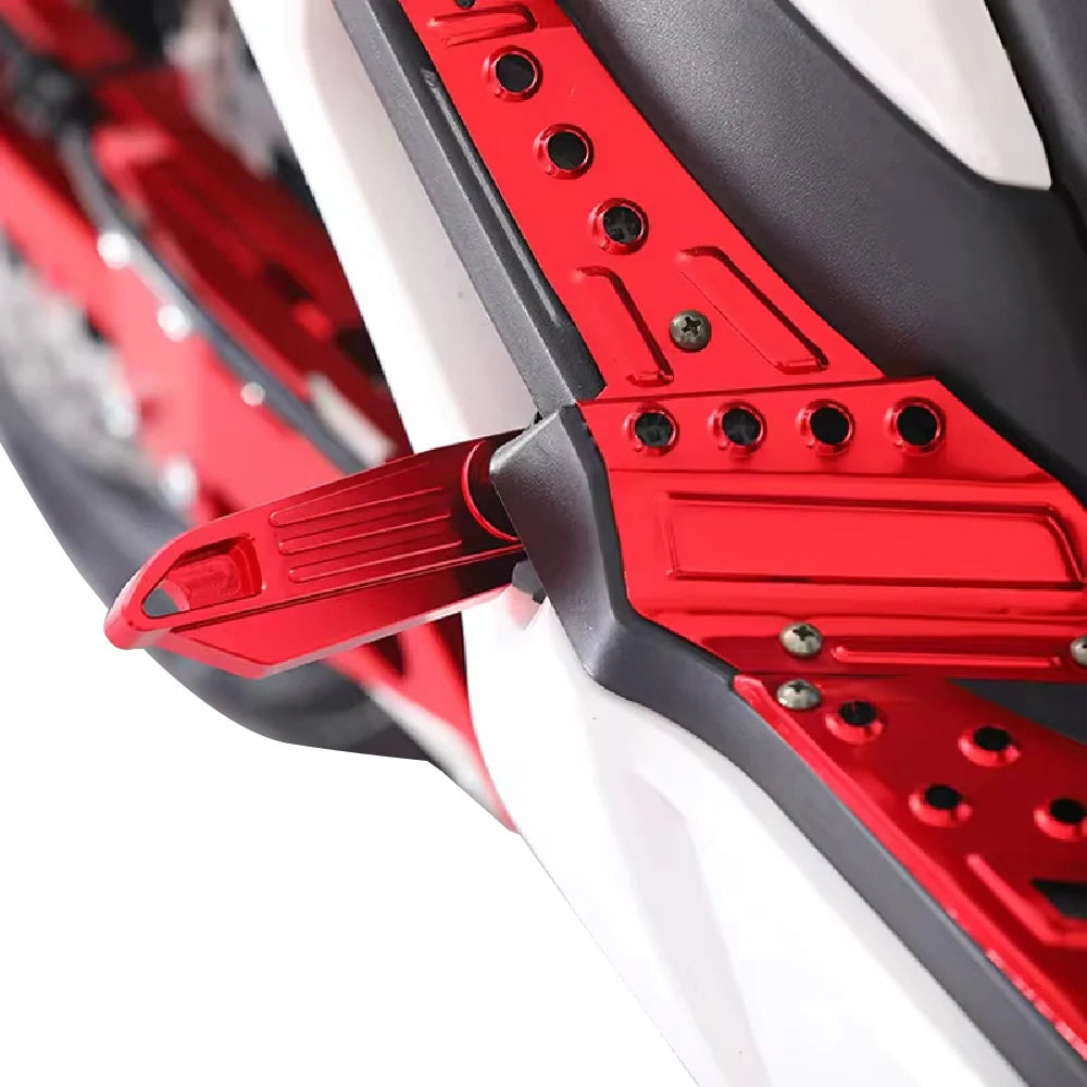 Close-up of a red motorcycle foot peg on a white background