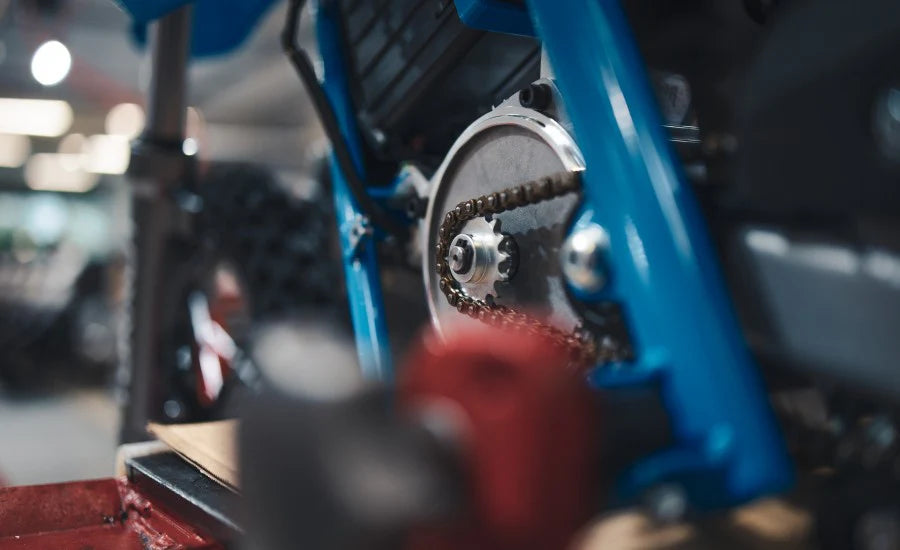 Close-up of a mechanical component with gears and a chain on a blurred background