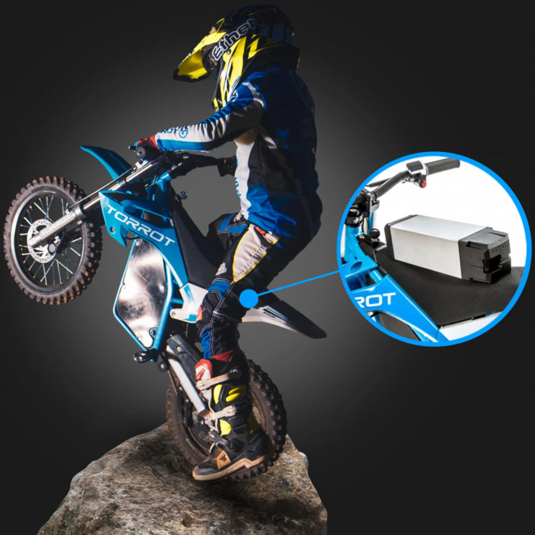 Motorcycle rider performing a stunt on a dark background with a close-up of the motorcycle's battery pack.