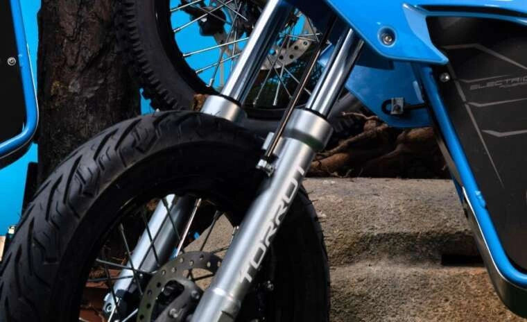 Close-up of a motorcycle's suspension fork with a blue frame.