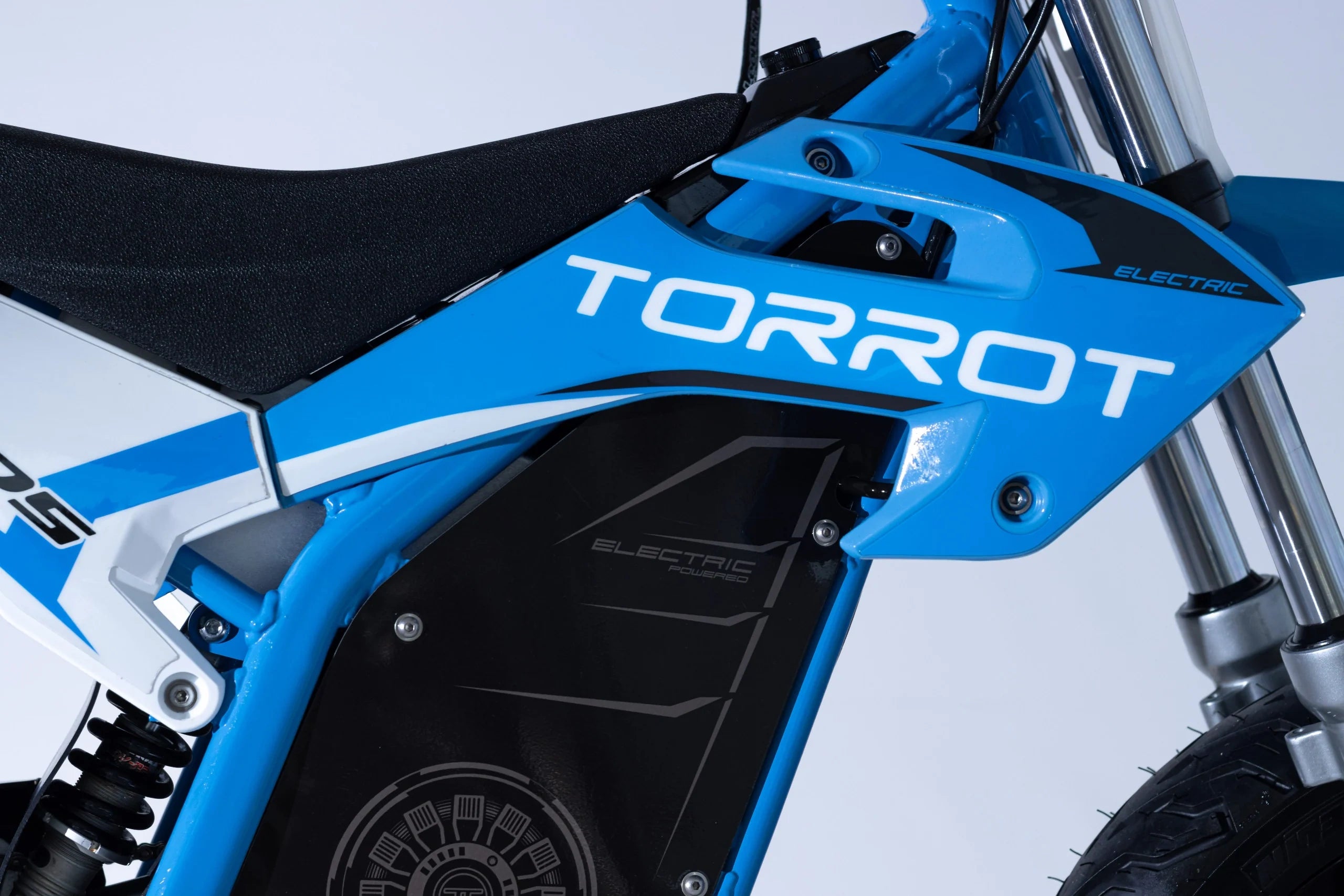 Close-up of a blue dirt bike with 'TORROT' branding on a light gray background