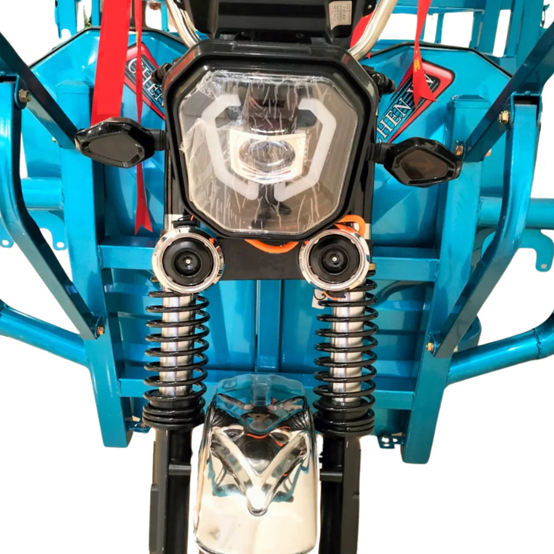 Close-up of a blue off-road vehicle's front suspension and headlight on a white background