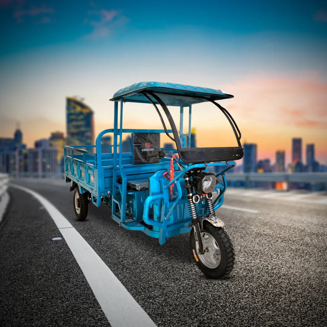 Blue three-wheeled vehicle on a road with a cityscape in the background