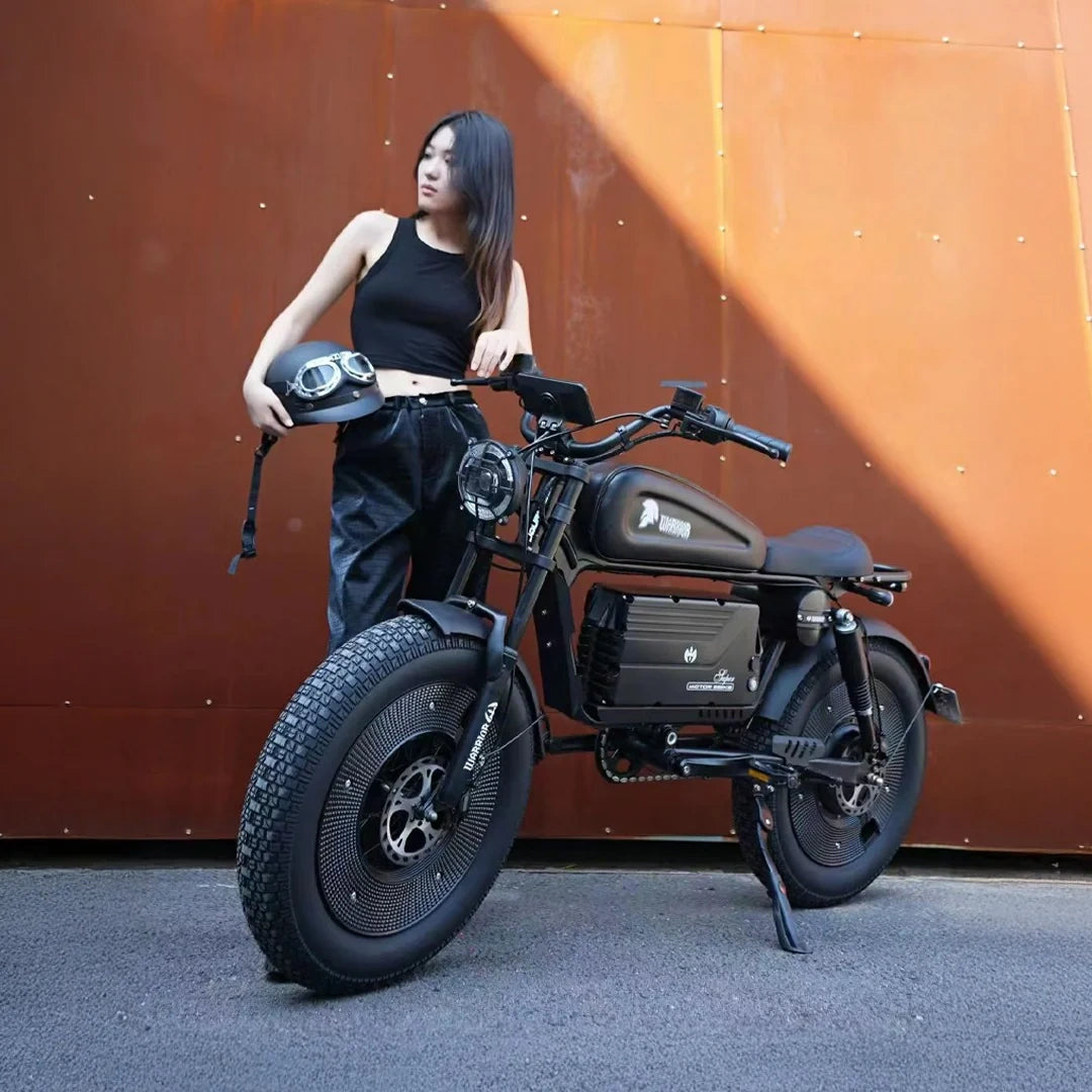 Woman holding a helmet next to a black motorcycle against an orange wall.