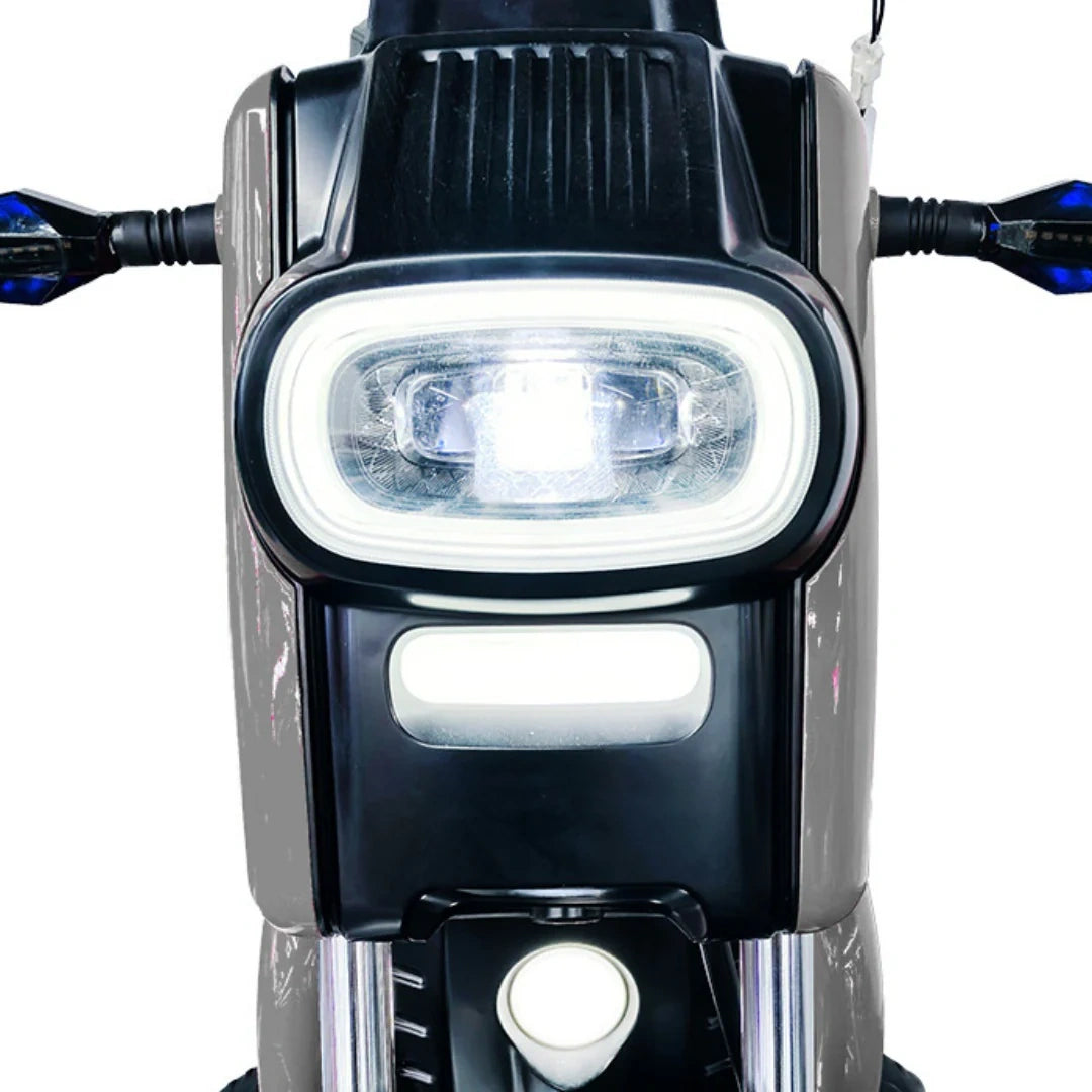 Close-up of a motorcycle headlight with a white light on a white background