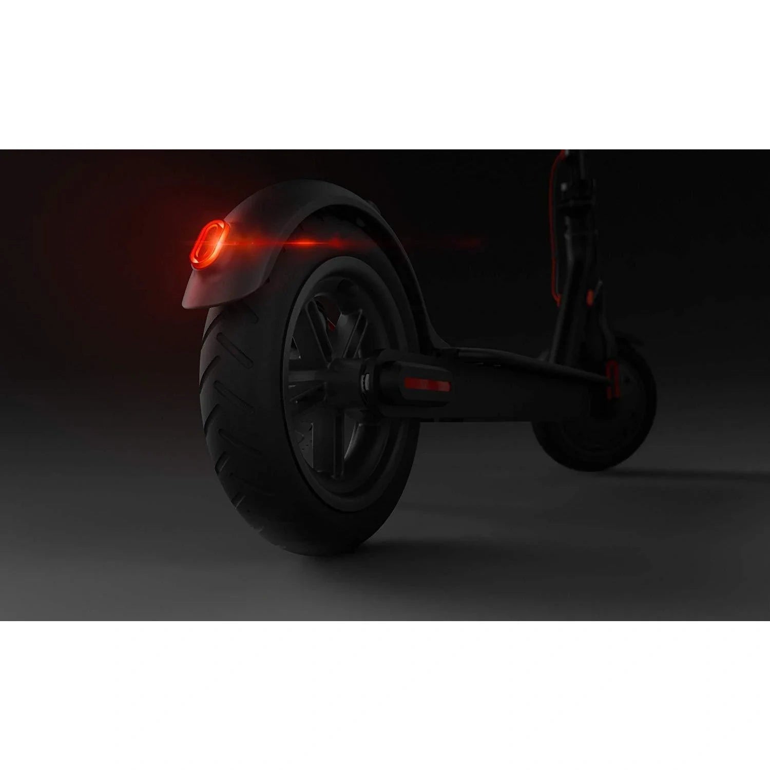 Dark scooter with a red light on a black background