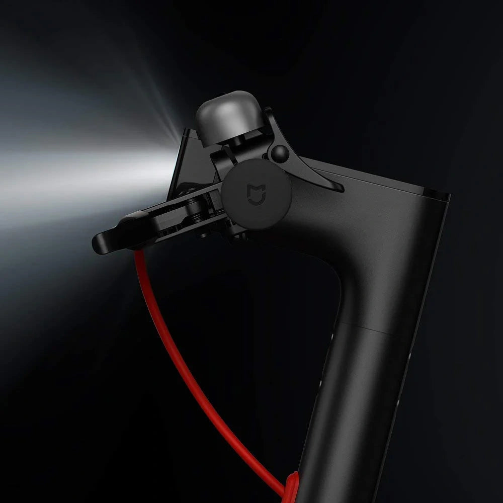 Black handheld vacuum cleaner with red cord on a dark background