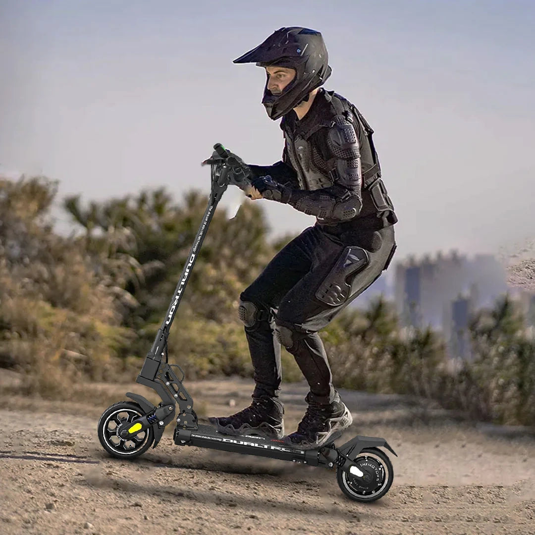Person riding a scooter in a desert-like environment wearing protective gear.